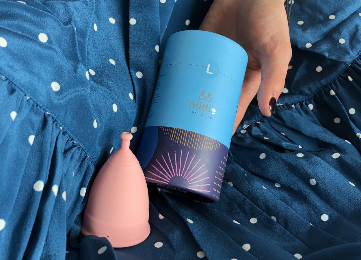 Woman holding &SISTERS nudie menstrual cup