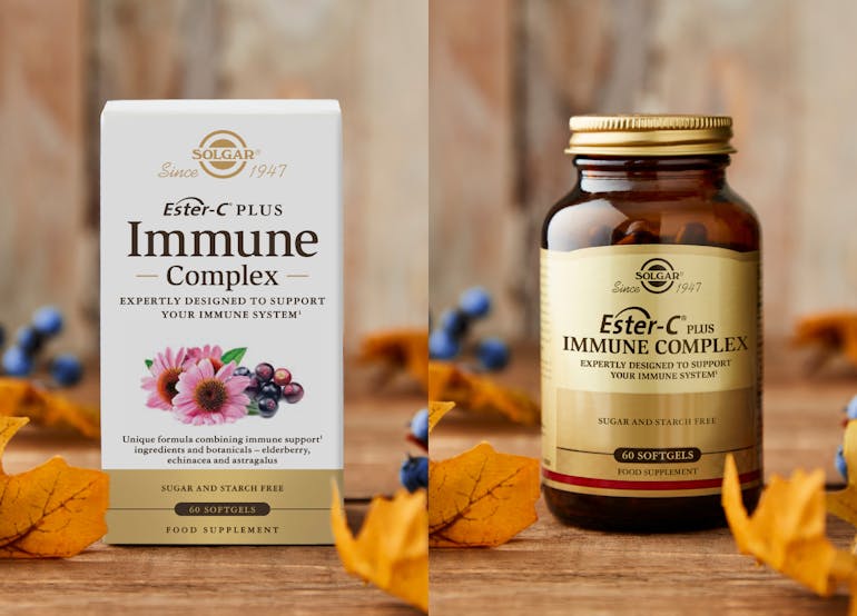 Solgar Ester-C immune complex supplements on a wooden background with winter leaves and berries