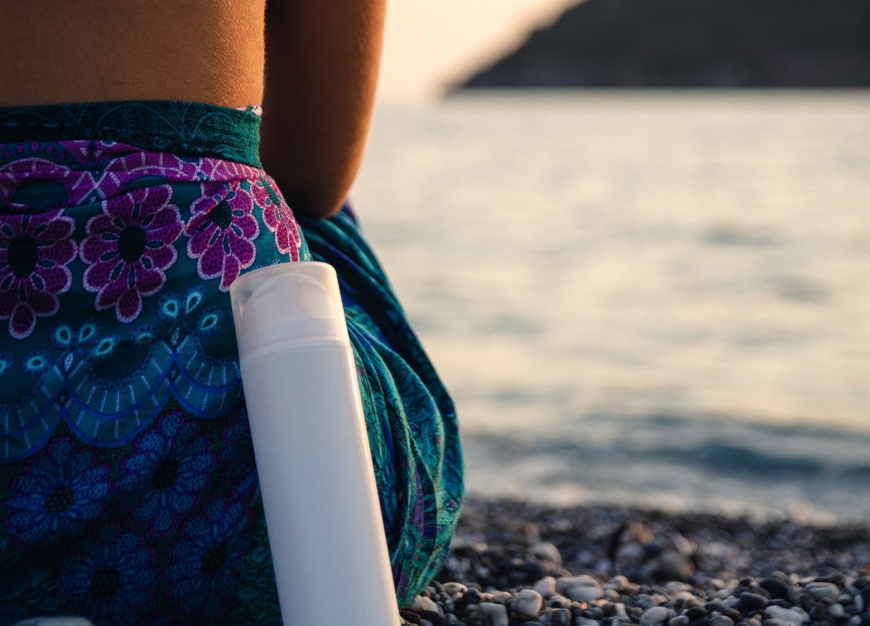 Woman on the beach with sun lotion